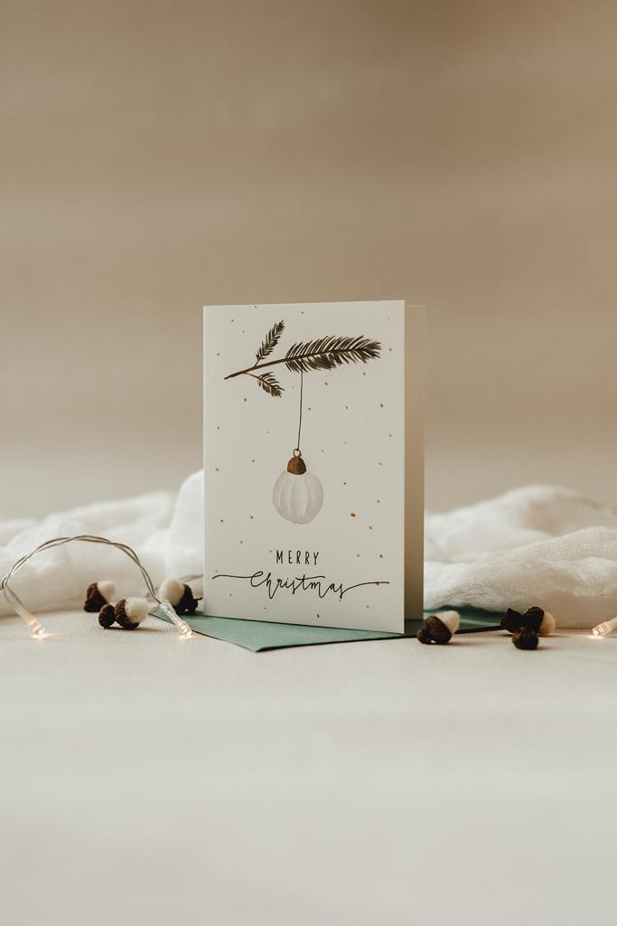 von Hand bemalte Klappkarte mit Christbaumkugel und Mispelzweig. Aufschrift: Merry Christmas. In sehr hellen,zarten Farben.